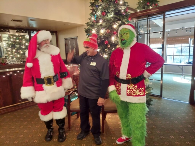 Luis Esparza, Facilities Manager at The Oaks of Pasadena for 35 years (as of 2025), having fun with Santa and The Grinch