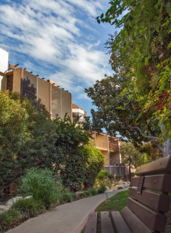 The senior independent living apartments at The Oaks of Pasadena overlooking park benches and paved walkways