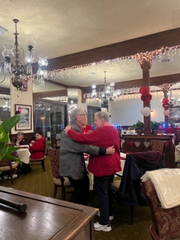 Residents enjoying a Valentine’s Day dance at The Oaks of Pasadena senior living apartments, featuring live music, decorations, and social engagement
